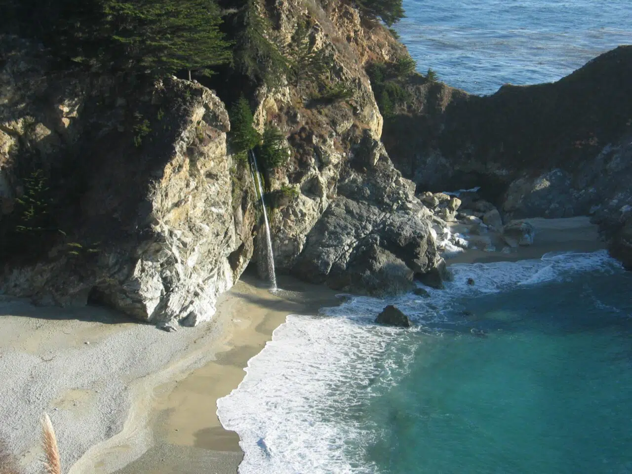 View of an ocean inlet and rocky shore from above.